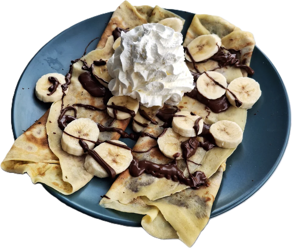 Folded crêpes on a blue plate, topped with sliced banana, chocolate sauce and a swirl of whipped cream